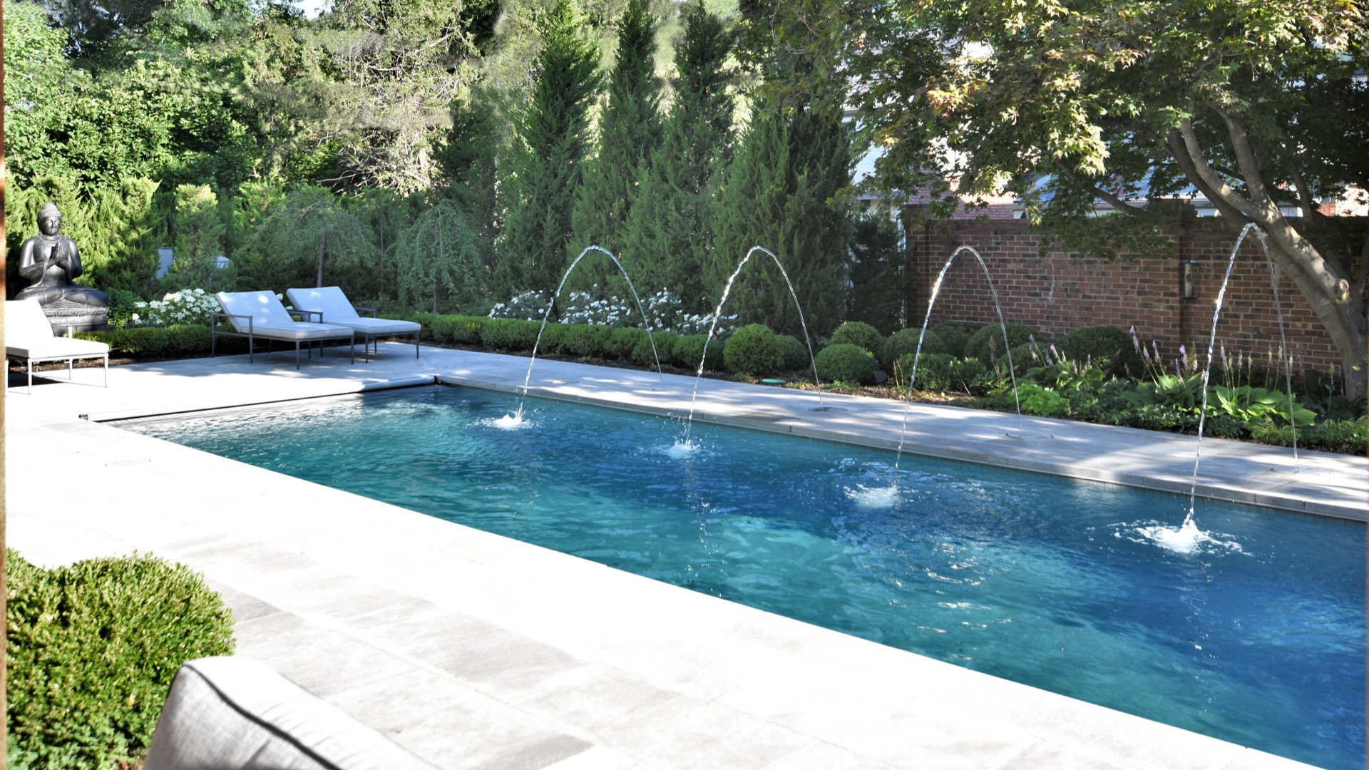 Stunning swimming pool with fountains and landscaping all around it in Overland Park, KS.