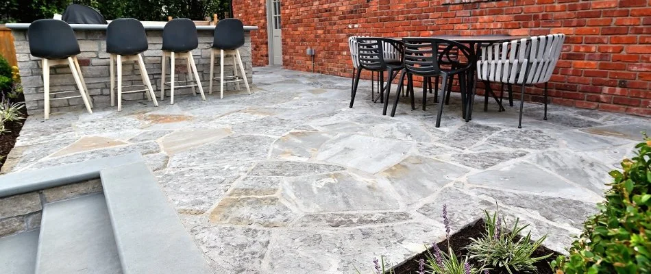 Flagstone patio in Overland Park, KS, with chairs and bar seating.