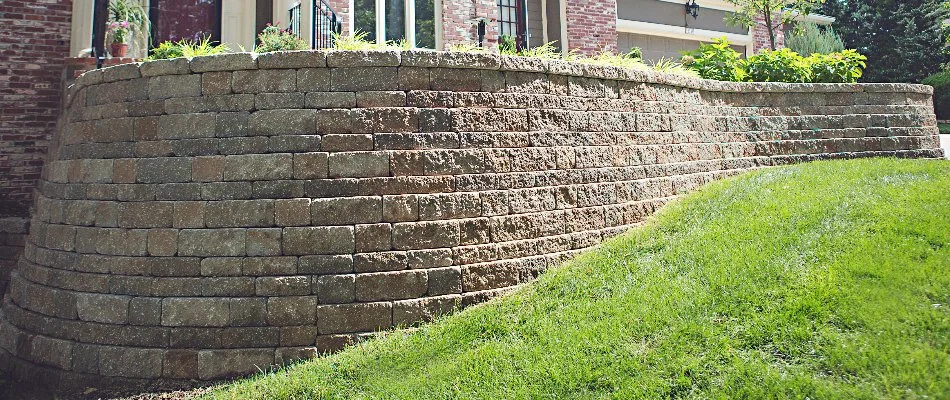 A high retaining wall in Overland Park, KS, beside a sloped lawn.