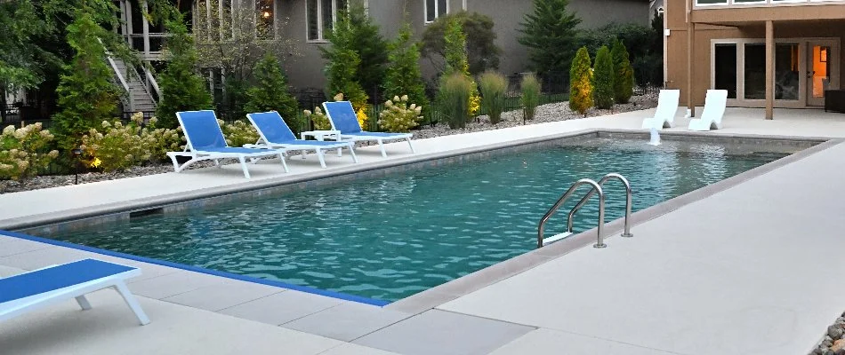 Lounge chairs and landscape plants around a gunite pool in Overland Park, KS.