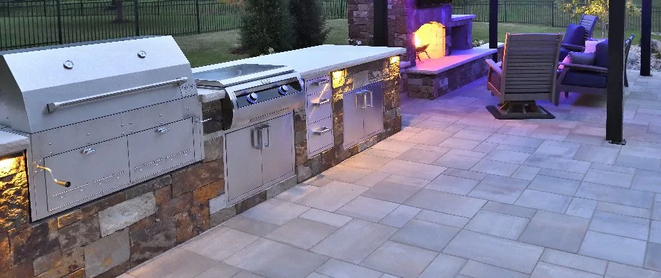 Outdoor fireplace beside an outdoor kitchen in Overland Park, KS.