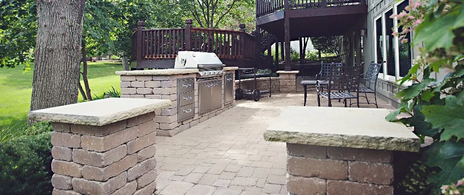 Outdoor kitchen on a patio in Overland Park, KS, with a seating wall.