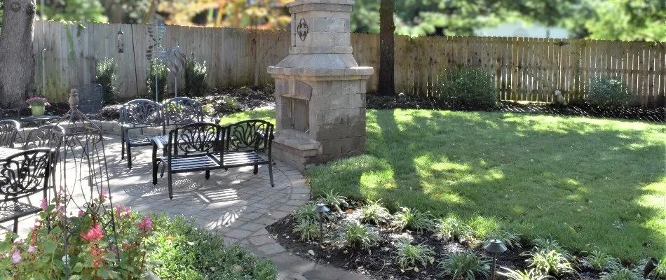 Outdoor space in Overland Park, KS, with outdoor fireplace, patio, and lawn.