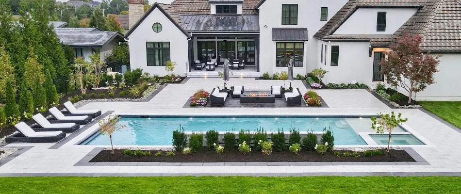 Outdoor space in Overland Park, KS, with a pool, fire pit, and landscaping.