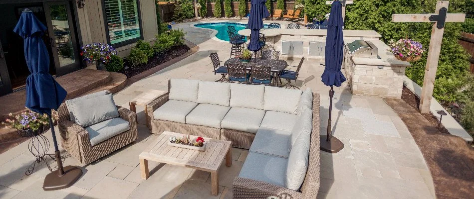 Patio in Overland Park, KS, with furniture and outdoor kitchen near a pool.