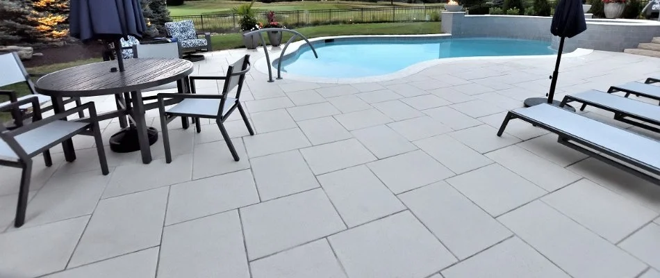 Paver patio in Overland Park, KS, with a pool and outdoor furniture.