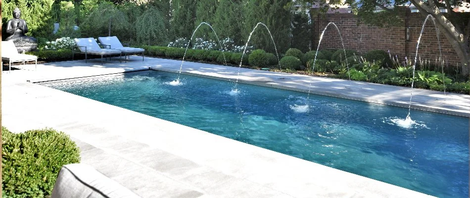 Pool in Overland Park, KS, with small fountains and a pool deck.