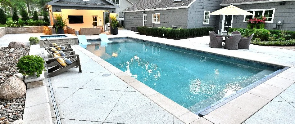 Rectangular pool in Overland Park, KS, with decking and chairs.