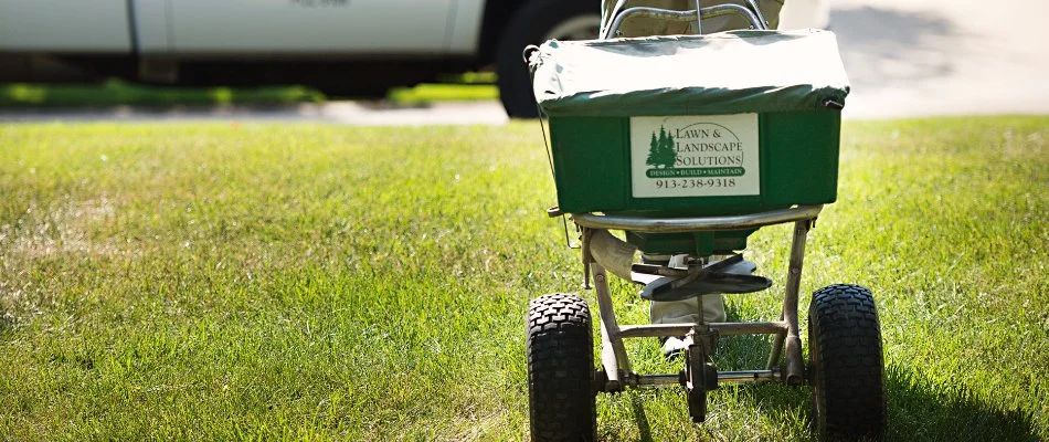 Spreading granular fertilizer on a lawn in Overland Park, KS.