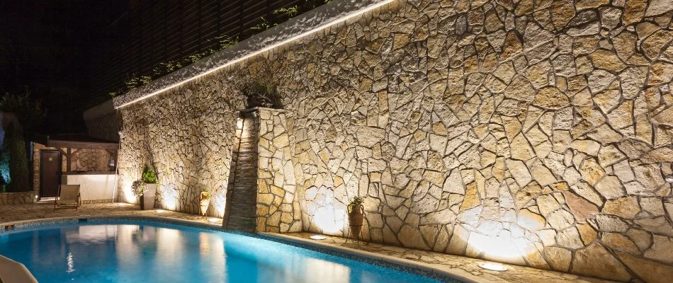 Textured wall with a lighting fixture in Overland Park, KS, by a pool.