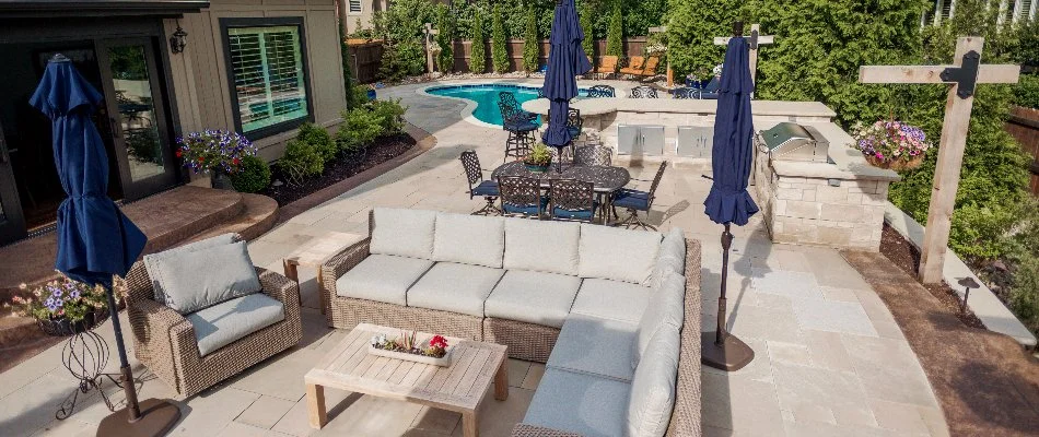 Backyard patio in Belton, MO, with seating, kitchen, and a pool.