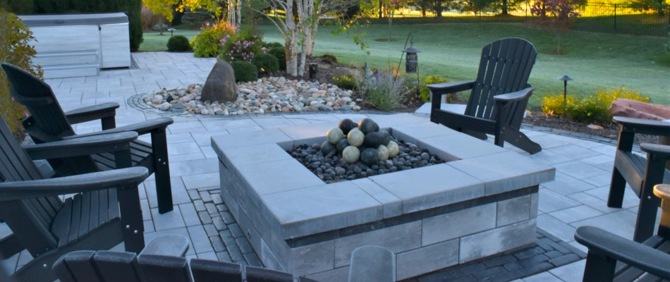 Newly installed modern fire pit with seeting and a patio.