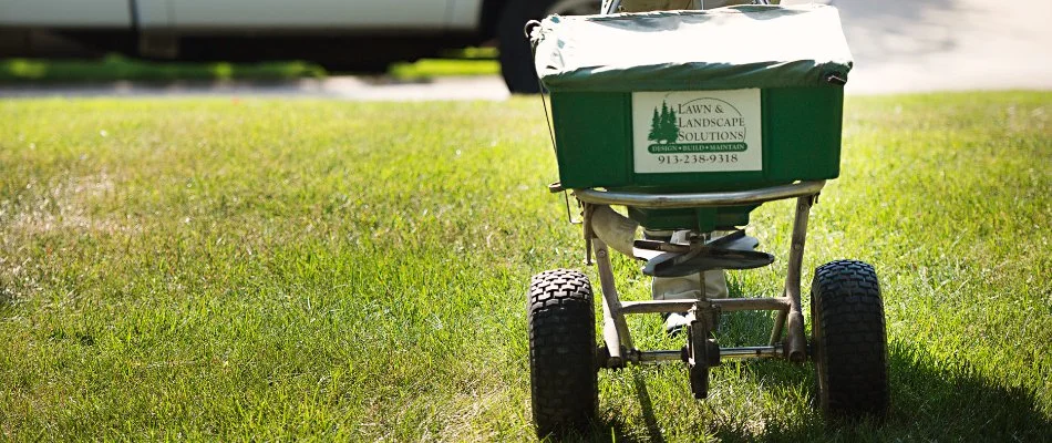 Granular fertilizer spreader on a lawn in Spring Hill, KS.