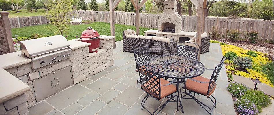 Outdoor kitchen beside an outdoor fireplace in Raymore, MO.