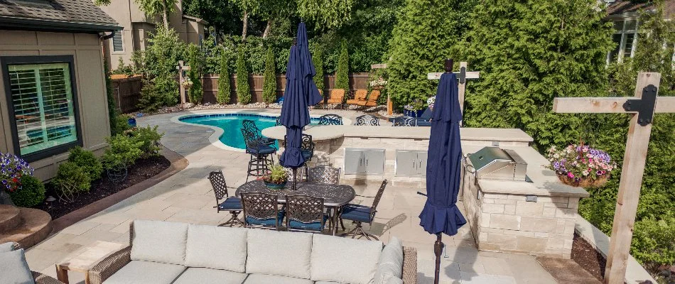 Outdoor kitchen and umbrellas near a pool in Lee's Summit, MO.