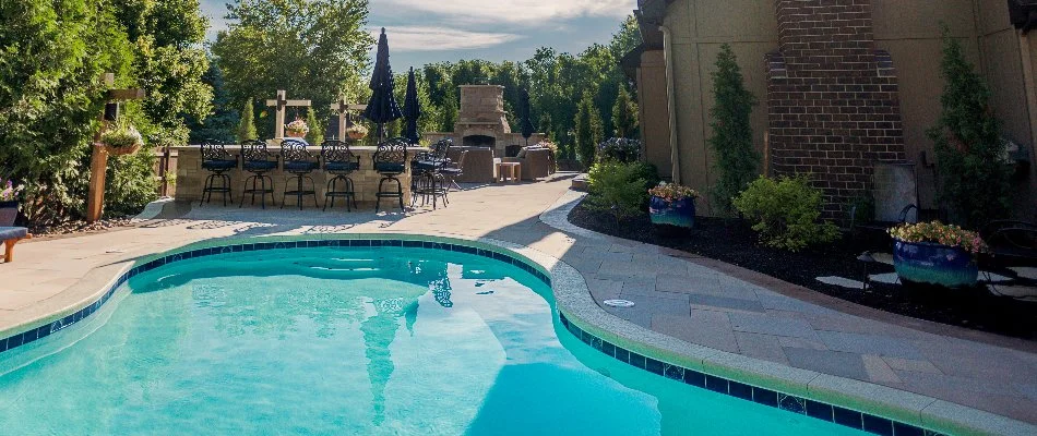 Outdoor space in Cleveland, MO, with landscaping, swimming pool, and outdoor fireplace.