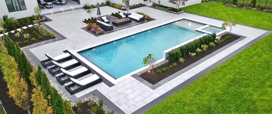 Paver patio around a pool with landscape beds in Fairway, KS.