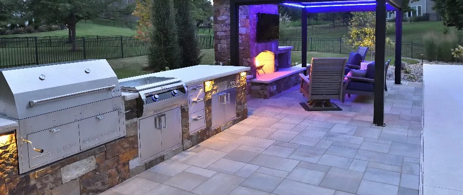 Paver patio with an outdoor kitchen and fireplace in Leawood, KS.