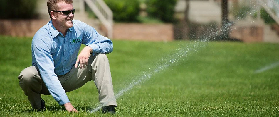 Professional adjusting a sprinkler head in Lake Quivira, KS.