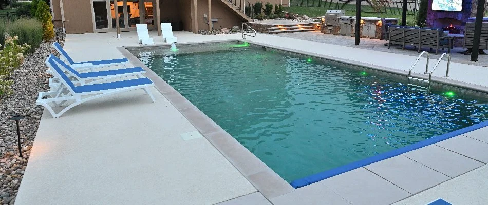 Rectangular pool in Leawood, KS, with lighting and lounge chairs.