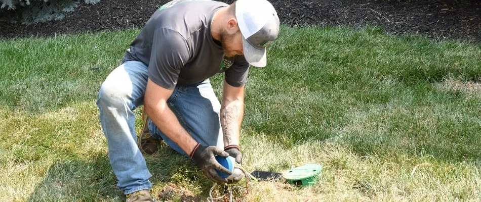 Expert technician repairing underground irrigation system.