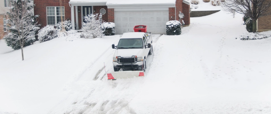 A truck clearing a residential driveway of snow in Leawood, KS.