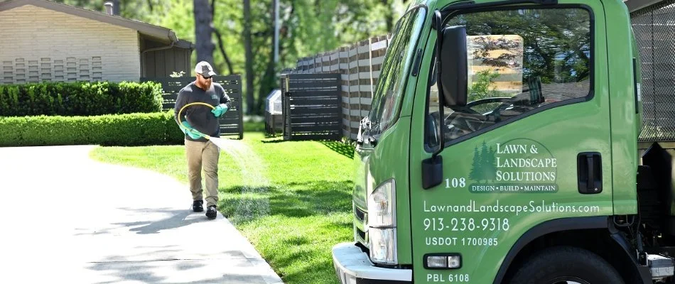 Worker applying a lawn care treatment on a property in Lake Winnebago, MO.