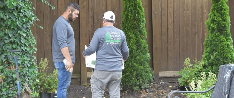 Experts discussing landscaping project plan in Leawood, KS.